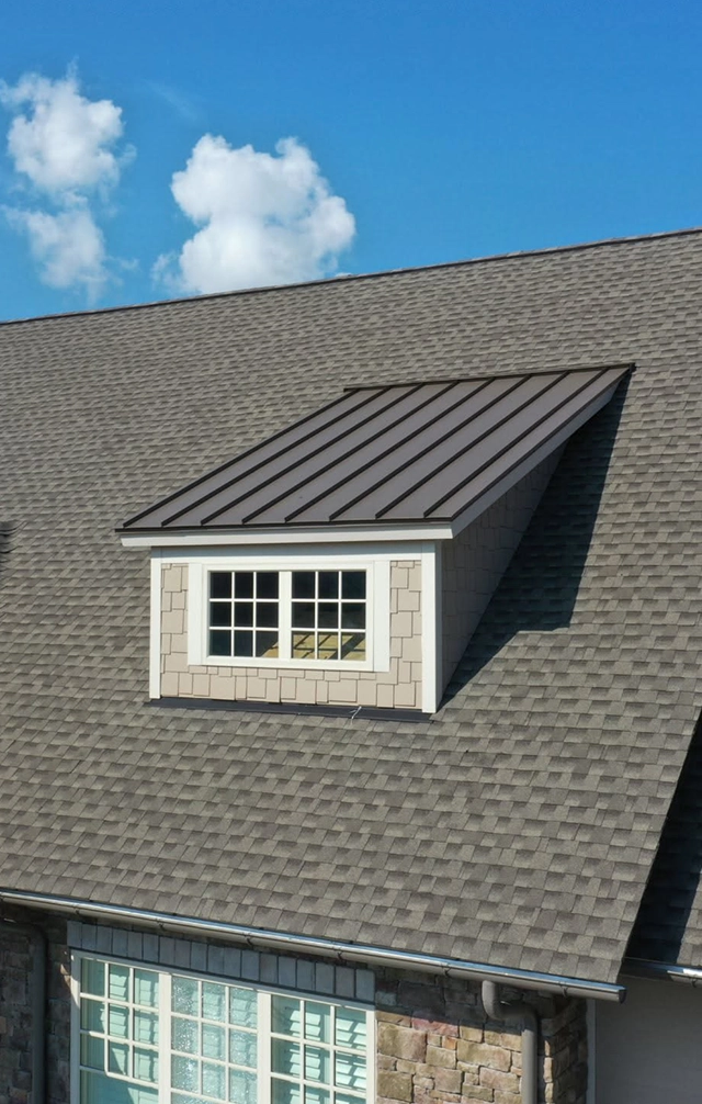Skylight installed on sloped roof with cloudy sky background.